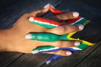 Verschränkte Hände, eine ist mit der südafrikanischen Flagge bemalt. Foto: Kathrin Linke/Fotolia.com