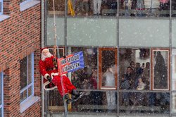 Vom Himmel herab: Im Nikolaus-Kostüm seilte sich ein Höhenretter der Oldenburger Berufsfeuer am Gebäude des Kinderkrankenhauses ab und zeigte ein Plakat mit der Aufschrift „Ihr seid die Stärksten“. Foto: Sascha Stüber