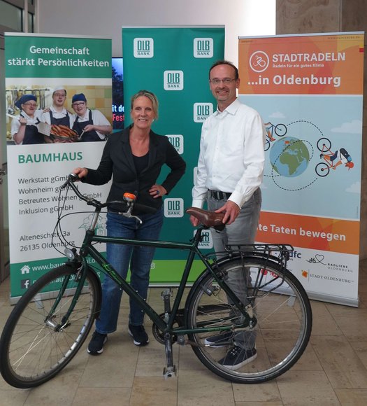 Holger Sandker, Director Head of Sustainability der Oldenburgischen Landesbank AG, und Bettina Unruh, Geschäftsführerin der Baumhaus gGmbH, freuen sich über das Erreichen des Etappenziels. Foto: Stadt Oldenburg