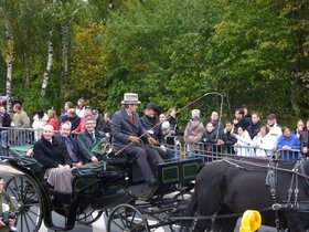 Ein schwarzes Pferd zieht eine Kutsche, in der drei Männer sitzen, im Hintergrund Zuschauerinnen und Zuschauer. Foto: Stadt Oldenburg