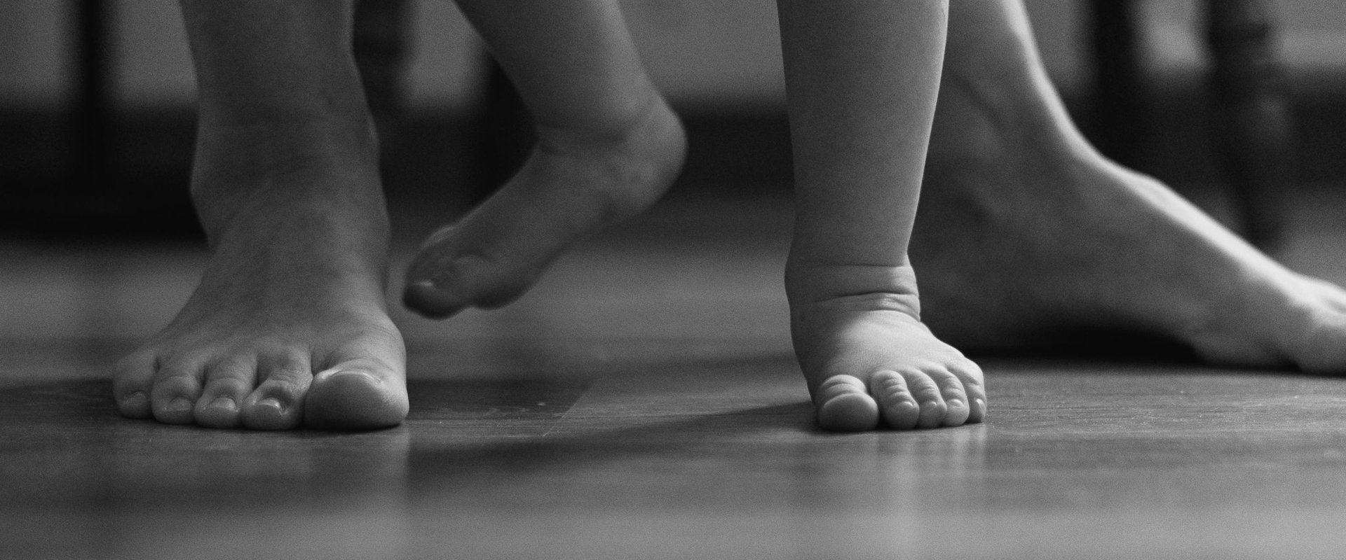 Elternteil und Kind laußen barfuß. Foto: Albina White/pexels