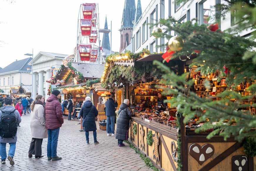Sascha Stüber Drudo Lederwaren mit Blick in Richtung Nostalgie Riesenrad auf dem Lamberti-Markt 2025. Foto: Sascha Stüber