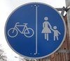 Beschilderung getrennter Geh- und Radweg, weißes Fahrradpiktogramm und weißes Fußgängerpiktogramm nebeneinander auf blauem Hintergrund. Foto: Stadt Oldenburg