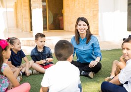Kinder sitzen mit einer Erzieherin im Kreis. Foto: tonodiaz/Freepik