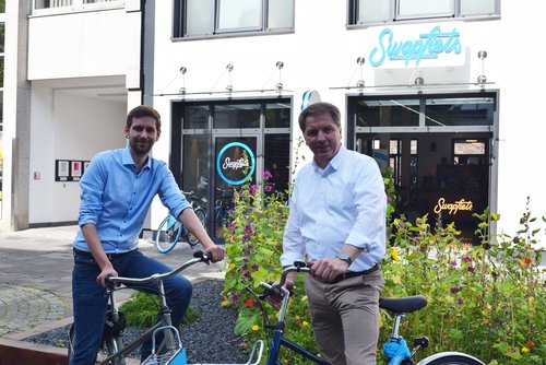 Yannik Duwe und Oberbürgermeister Jürgen Krogmann stehen vor „Swapfiets“. Foto: Stadt Oldenburg.