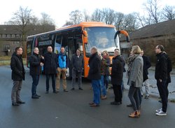 Geführte Rundfahrt über den Fliegerhorst. Foto: Stadt Oldenburg Menschen stehen vor einem orangefarbenen Bus mit Groningen-Aufschrift. Foto: Stadt Oldenburg
