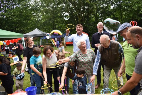 Tobten sich gemeinsam mit einigen Kids bei den Seifenblasen aus (von links): Ruth Braun (Leiterin des Abenteuerspielplatzes), Sozialdezernentin Dagmar Sachse, Dr. Frank Lammerding (Leiter des Amtes für Jugend und Familie), Inge Stutz (Ehefrau des ersten Leiters des Abenteuerspielplatzes), Christian Fritsch (Fachdienstleiter Jugend und Gemeinwesenarbeit), Claus Finke (ehemaliger Leiter der Ferienpassaktion), Michael Köhler (langjähriger Leiter des Abenteuerspielplatzes) und Ingo Krüger (Koordinator Ferienpassaktion). Foto: Stadt Oldenburg