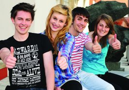 Vier Jugendliche sitzen nebeneinander und zeigen lachend „Daumen hoch“. Foto: klickit/ Fotolia.de