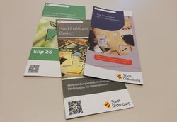 Drei Flyer zum Thema Nachhaltigkeit und Klimaschutz für Unternehmen liegen auf einem Tisch. Foto: Stadt Oldenburg