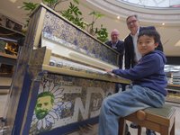 Der elfjährige Dominic Chen spielte als Erster auf dem Piano. Oberbürgermeister Jürgen Krogmann und Center-Manager Stefan Tenk (links) waren begeistert. Konterfei und Unterschrift von Klaas Heufer-Umlauf zieren das Instrument. Foto: Sascha Stüber Foto: Sascha Stüber