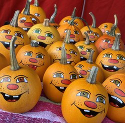Kürbisse mit aufgemalten Gesichtern an einem Stand auf dem Wochenmarkt. Foto: Stadt Oldenburg