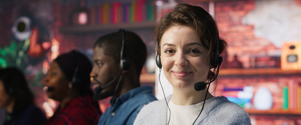 Freundliche Mitarbeiterin mit Headset im Servicebüro. Bild: Freepik 