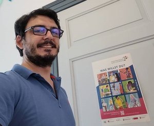 Ilker Besken vor seinem Büro im Kulturzentrum PFL mit Jubiläumsplakat. Foto: Stadt Oldenburg Ilker Besken (rechts) vor seinem Büro im Kulturzentrum PFL mit Jubiläumsplakat. Foto: Stadt Oldenbur