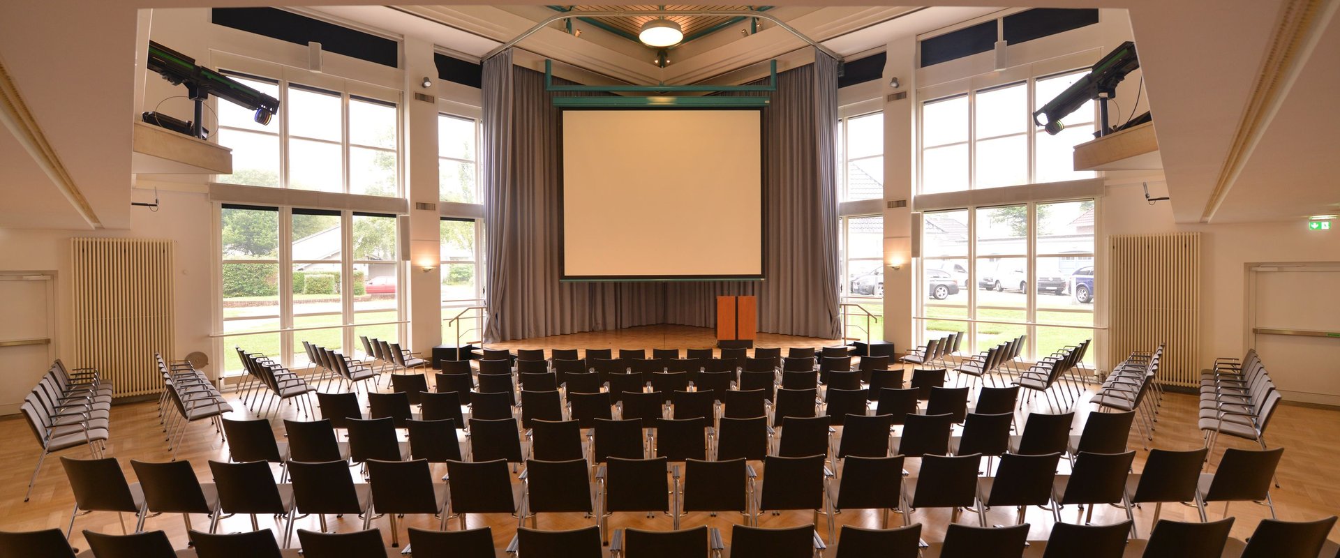 Veranstaltungssaal des PFL mit heruntergelassener Leinwand, Blick vom Eingangstür. Foto: Jörg Hemmen