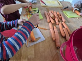 Kinder helfen beim Karottenschälen