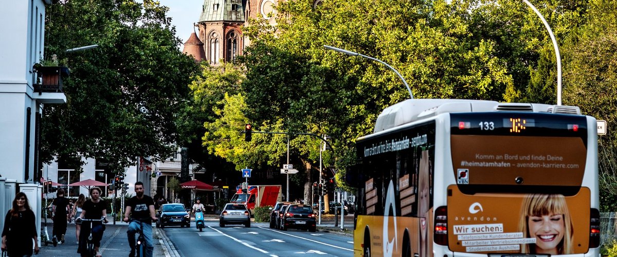 Blick von der Gartenstraße Richtung Kasinoplatz mit Fußgängerin, Radfahrenden, Autos, Mofa und Bus. Foto. Mittwollen und Gradetchliev
