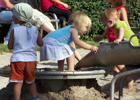 Kinder spielen draußen auf einem Spielplatz. Foto: knipseline/Pixelio.de
