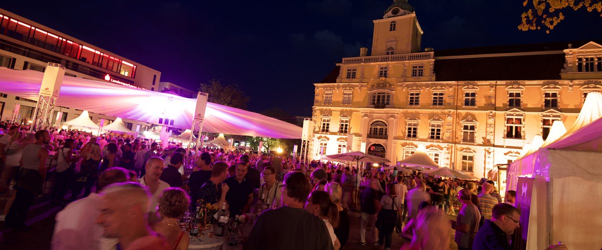 Blick auf die Veranstaltung Kochen am Schloss im Dunkeln, im Hintergrund das beleuchtete Schloss. Foto: E&M Marketing