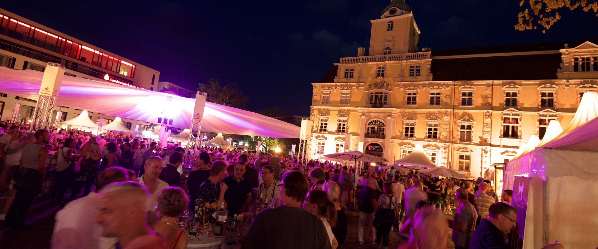 Blick auf die Veranstaltung Kochen am Schloss im Dunkeln, im Hintergrund das beleuchtete Schloss. Foto: E&M Marketing
