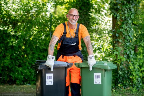 Ein Müllwerker des Abfallwirtschaftsbetriebs Stadt Oldenburg mit einer Rest- und Biotonne. Foto: Hauke-Christian Dittrich