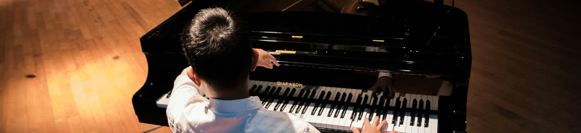 Junge sitzt und spielt am Flügel. Foto: Ludawigakwana/Pexels