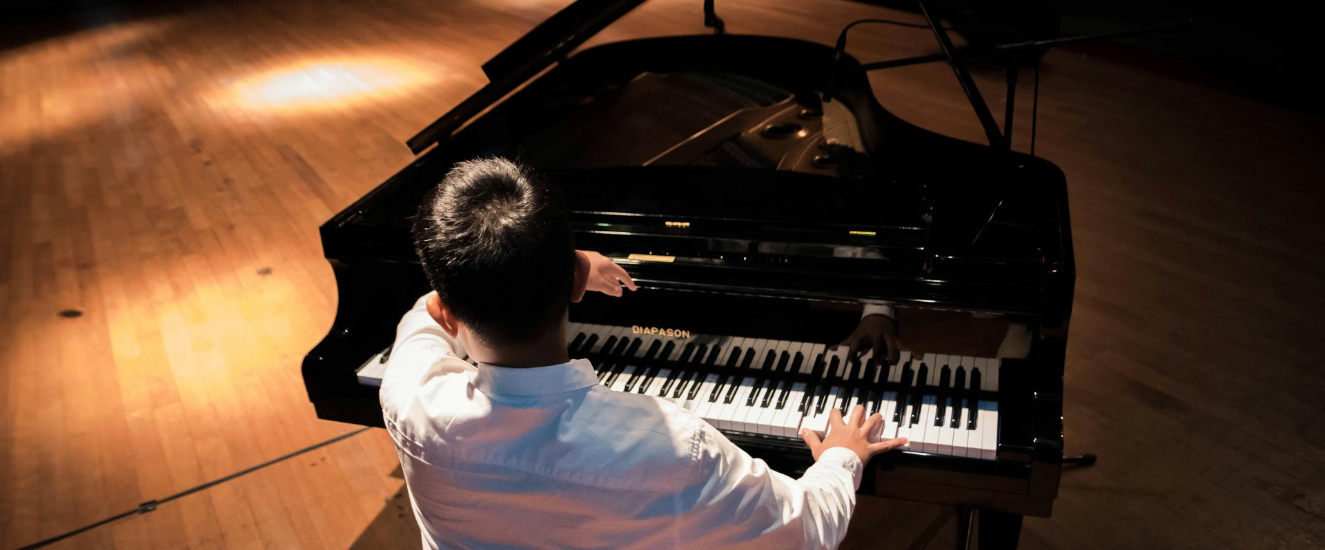 Junge sitzt und spielt am Flügel. Foto: Ludawigakwana/Pexels