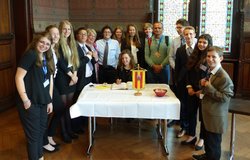 Bürgermeisterin Germaid Eilers-Dörfler empfängt eine Schülergruppe aus Israel im Rathaus. Foto: Stadt Oldenburg Eine Gruppe junger Menschen steht neben und hinter einem Tisch mit weißer Tischdecke und dem Wappen Oldenburgs. Am Tisch sitzt eine junge Frau und schreibt in das Gästebuch. Foto: Stadt Oldenburg