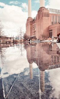 Architektur in London: Hier spiegelt sich die bekannte Battersea Power Station mit ihren vier Türmen in einem See wider. Foto: Anthea Wicherts