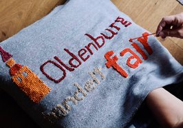 Ein Kissen wird mit dem Logo von „Oldenburg handelt fair" bestickt. Foto: F. Beck und J. Bädeker