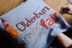 Ein Kissen wird mit dem Logo von „Oldenburg handelt fair" bestickt. Foto: F. Beck und J. Bädeker