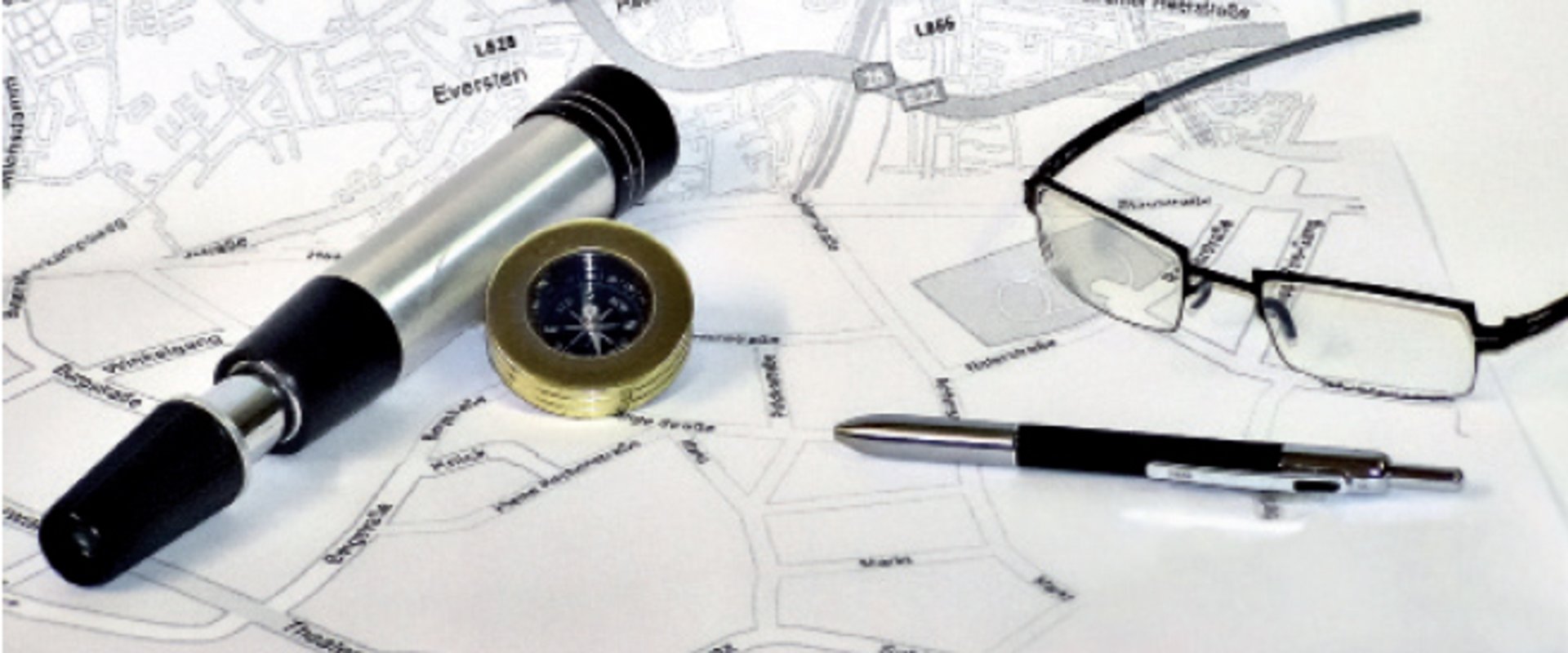 Stadtplanausschnitt mit Brille, Stift und Kompass. Foto: Stadt Oldenburg