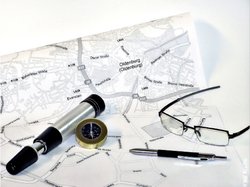 Stadtplanausschnitt mit Brille, Stift und Kompass. Foto: Stadt Oldenburg