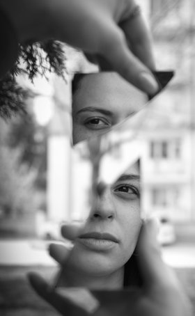 Symbolbild: Eine Frau ist in einem zerbrochenen Spiegel zu sehen. Foto: Kağan Karatay/Pexels.