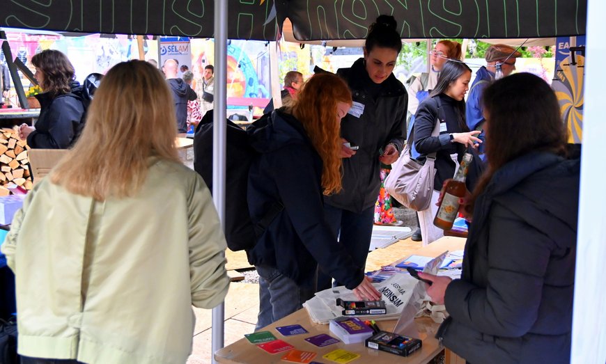 Zwei junge Frauen begutachten interessiert einen Informationsstand. Foto: Robert Gertzen 