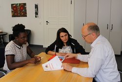 Rose (1. von links) und Alexane zeigen Frank Hinrichs, Leiter Büro des Oberbürgermeisters, ihre Berichtsvorlage. Foto: Stadt Oldenburg Rose und Alexane sitzen mit Frank Hinrichs, Leiter Büro des Oberbürgermeisters, an einem Besprechungstisch. Foto: Stadt Oldenburg