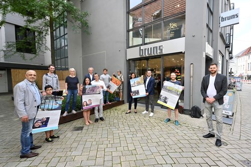Präsentierten die Plakate mit den Oldenburger Neubürgern: Innenstadtmanager Steffen Trawinski (rechts) und der Leiter des Amtes für Zuwanderung und Integration, Daniel Stellmann (dritter von links). Foto: Sascha Stüber
