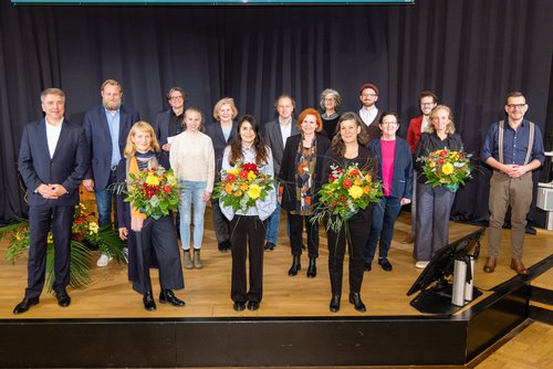 Gruppenbild: Die Preisträgerin Kerstin Gulden mit Oberbürgermeister Jürgen Krogmann, den Nominierten Enikö Gömöri und Michaela Beck sowie den Jurymitgliedern, Vertreterinnen und Vertretern des Oldenburger Stadtrats, Moderator Marian Funk und KIBUM-Schirmherr Bart Moeyeart. Foto: Martin Remmers