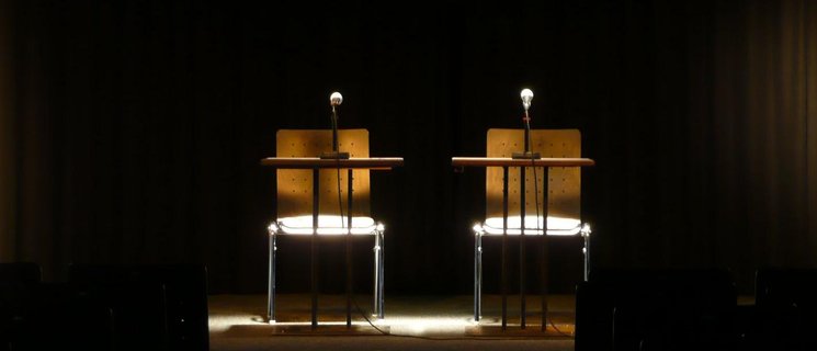 Leere Bühne mit zwei leeren Stühlen und Mikrofonen