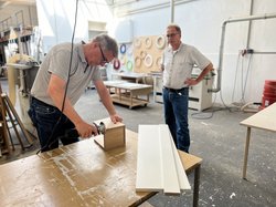 Unter den wachsamen Augen von Stefan Hoting (rechts) versucht sich Oberbürgermeister Jürgen Krogmann am Bau eines Vogelhauses in der Werkstatt. Foto: Stadt Oldenburg 