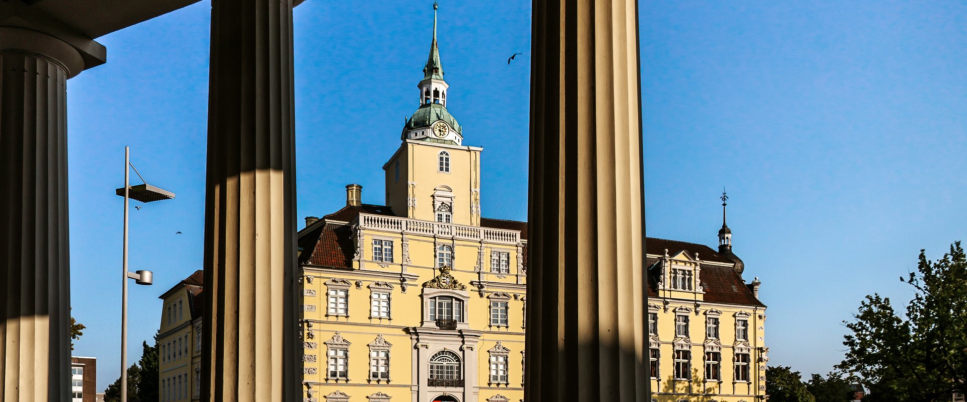 Schloss durch die Säulen der Schlosswache durch. Foto: Mittwollen und Gradetchliev