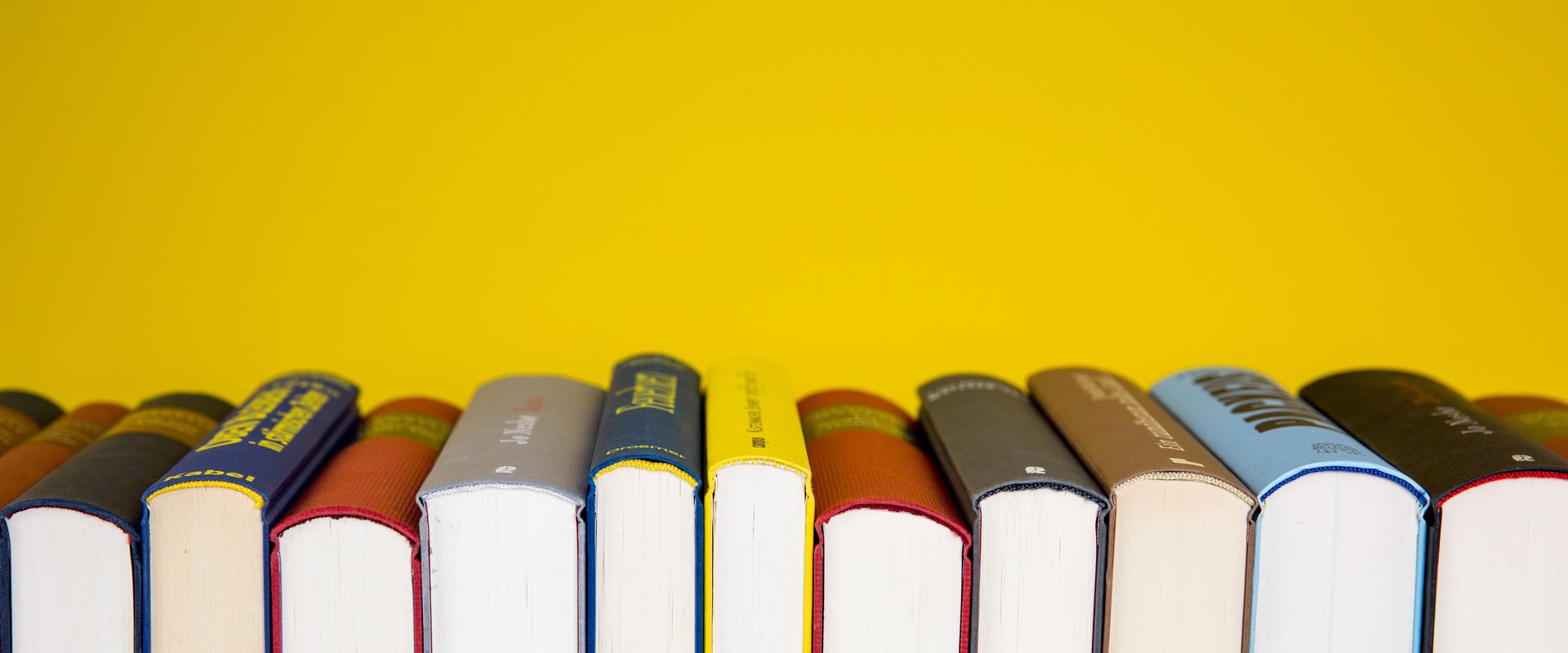 Bücher auf gelben Untergrund. Foto: Hermann/Pixabay