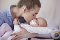 Mutter mit Baby auf dem Arm. Foto: Gpointstudio/Freepik