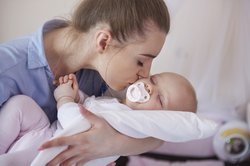 Mutter mit Baby auf dem Arm. Foto: Gpointstudio/Freepik