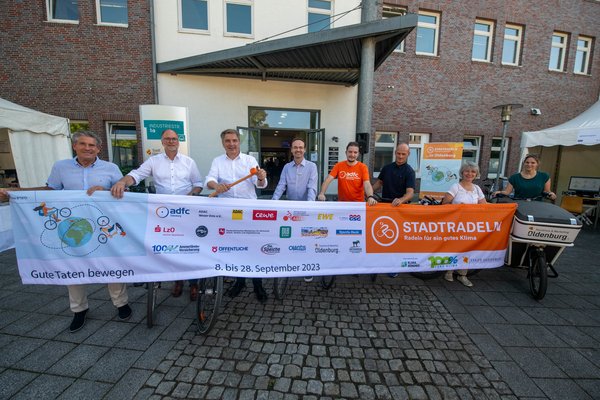 Oberbürgermeister Jürgen Krogmann gibt den Startschuss für STADTRADELN zusammen mit Vertreterinnen und Vertretern der Sponsoren. Foto: Sascha Stüber. Christian Bunk, Vertriebsdirektor, Öffentliche Versicherungen Oldenburg, Olaf Meenen, Abteilung Vorstandsstab und Geschäftsführer der LzO Stiftungen, Landessparkasse zu Oldenburg, Jürgen Krogmann, Oberbürgermeister, Stadt Oldenburg, Holger Sandker, Director Head of Sustainability, Oldenburgische Landesbank AG, Christian Lüdke, Vorstandsvorsitzender, ADFC Oldenburg e.V., Nils Linge, Pressesprecher, ADAC Weser-Ems e.V., Kerstin Goroncy, Koordinatorin STADTRADELN, Stadt Oldenburg und Gabriele Duwe, Produktentwicklung, Oldenburg Tourismus und Marketing GmbH stehen beim Startschuss zum STADTRADELN in Oldenburg hinter einem STADTRADELN-Banner. Foto: Sascha Stüber