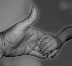 Erwachsenenhand und Kinderhand. Foto: Peter Bast/Pixelio