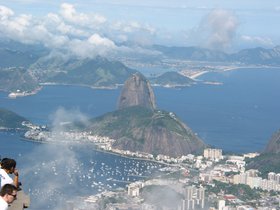 Ein Panoramafoto von Rio de Janeiro: in der Bildmitte der Berg Zuckerhut, umgeben von Meer und den küstennahen Bezirken der Stadt. Foto: Rainer Kaupil/Pixelio.de