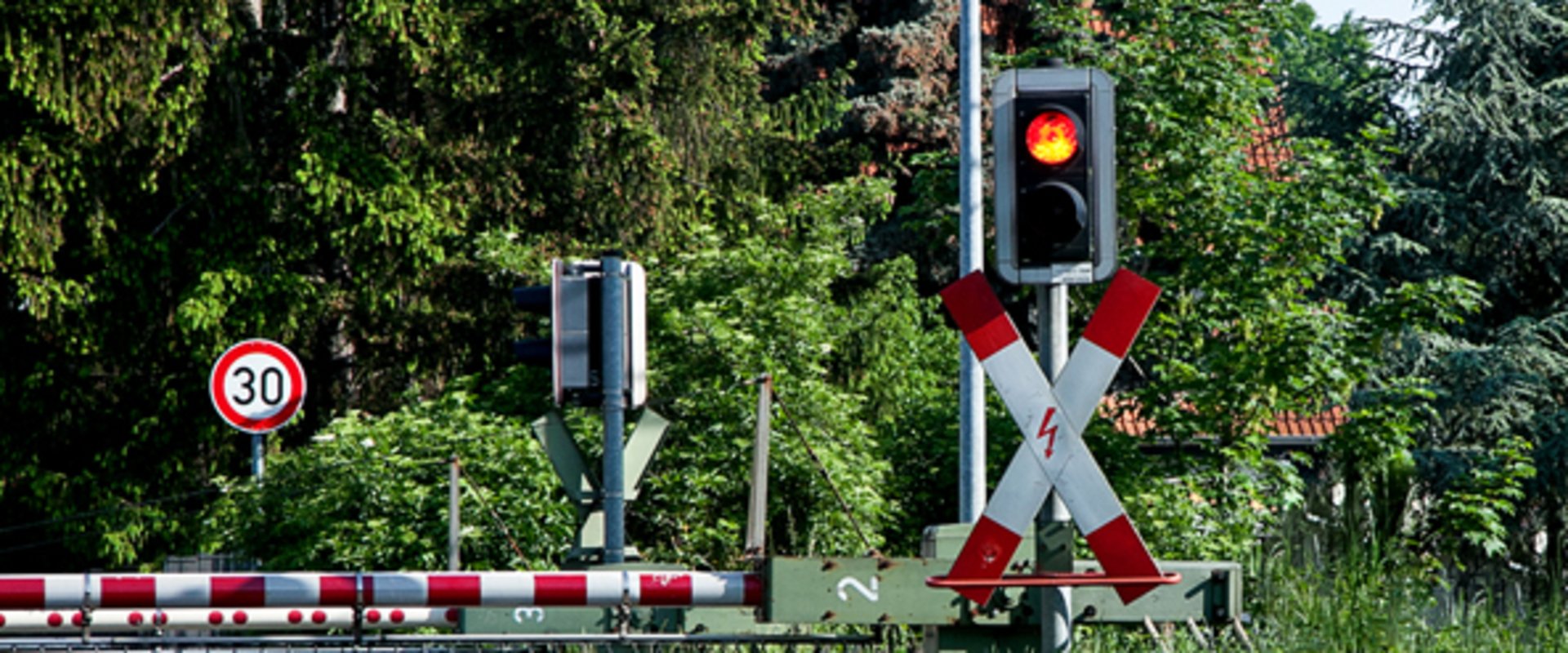 Mit Schranke und roter Ampel geschlossener Bahnübergang. Foto: Marianne J./Pixelio