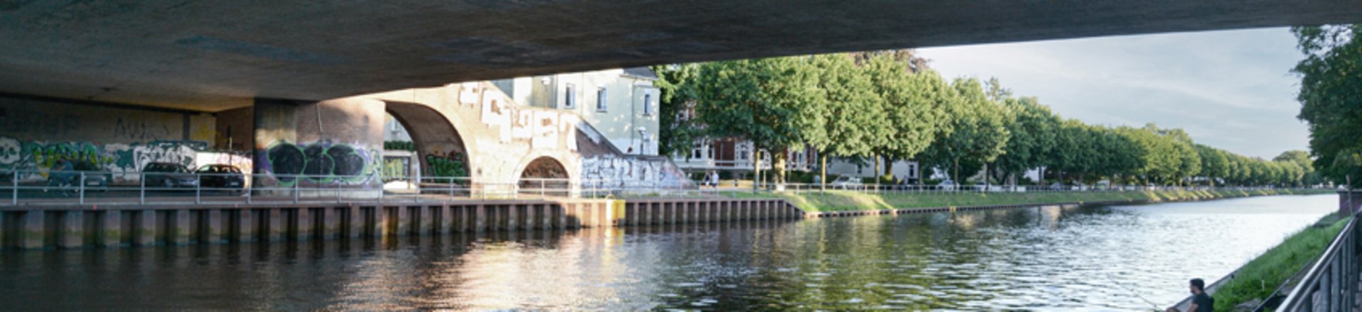 Blick unter einer Brücke hindurch auf den Oldenburger Hafen. Foto: Mittwollen und Gradetchliev