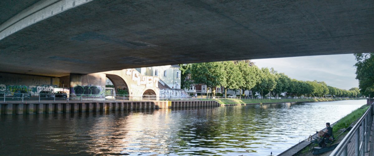 Blick unter einer Brücke hindurch auf den Oldenburger Hafen. Foto: Mittwollen und Gradetchliev