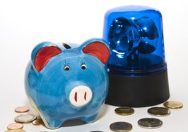 Sparschwein mit Blaulicht und Geld. Foto: Thorben Wengert/Pixelio